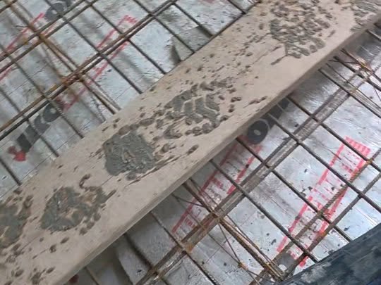 Wąż małej pompy do betonu ułożony na zbrojeniu płyty przed betonowaniem